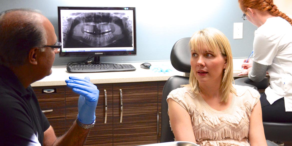 Dentist talks to patient.